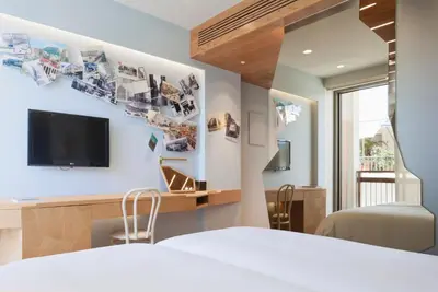 a bedroom with a bed and a tv on a wall at New Hotel in Athens