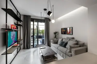 a living room with a couch and a tv at Syntagma Elysan Urban Stays in Athens