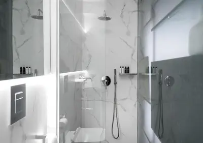 a bathroom with a shower with a glass door at Syntagma Elysan Urban Stays in Athens
