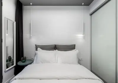 a white bedroom with a large bed with white pillows at Syntagma Elysan Urban Stays in Athens