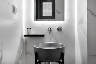 a bathroom with a tub and a sink and a mirror at Syntagma Elysan Urban Stays in Athens