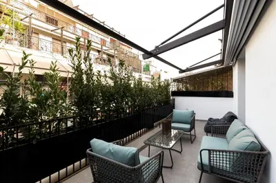 a balcony with chairs and tables and plants at Syntagma Elysan Urban Stays in Athens