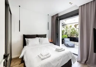 a bedroom with a large white bed and a balcony at Syntagma Elysan Urban Stays in Athens