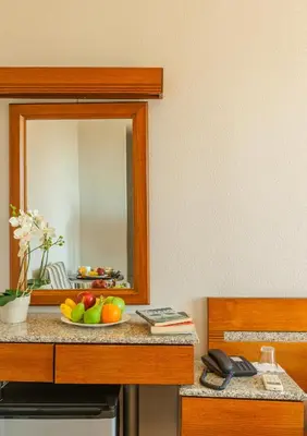 a mirror on a counter with a bowl of fruit at Park Hotel in Athens