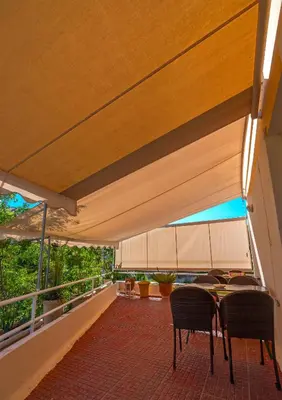 a patio with a table and chairs under awning at Park Hotel in Athens
