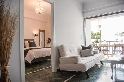 a bedroom with a bed and a couch and a mirror at Living near Acropolis by Sylvia Staikou 2nd & 3d floor in Athens