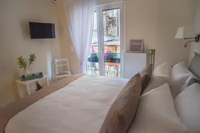 a large white bed in a room with a window at Living near Acropolis by Sylvia Staikou 2nd & 3d floor in Athens