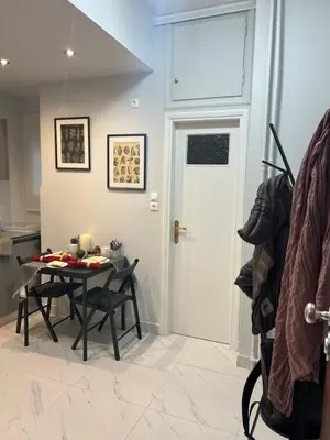 a dining room with a table and a white door at Living near Acropolis by Sylvia Staikou 2nd & 3d floor in Athens