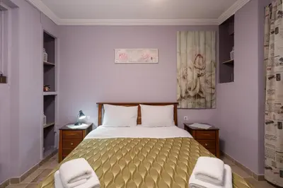 a bedroom with a bed and two chairs in it at The Sweetest Acropolis Flat in Athens