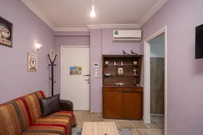 a living room with a couch and a book shelf at The Sweetest Acropolis Flat in Athens