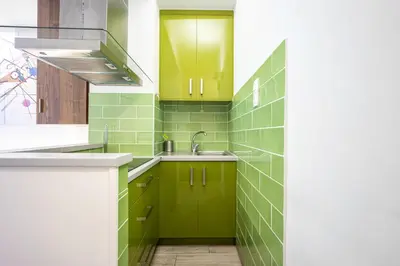 a green tiled kitchen with green cabinets and a sink at GK Mex in Athens