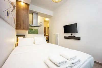 a bedroom with a large white bed with towels at GK Mex in Athens