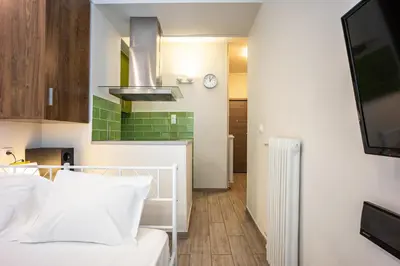 a bedroom with a white bed and a kitchen at GK Mex in Athens