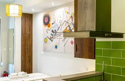 a kitchen with green tiles and a painting on the wall at GK Mex in Athens