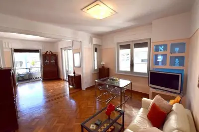 a living room with a couch and a tv at Spacious & Sunny Kolonaki Apt 5 mins metro/ACx3/1.5 BT in Athens