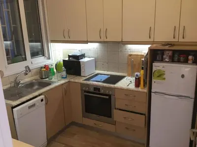a small kitchen with a sink and a refrigerator at Spacious & Sunny Kolonaki Apt 5 mins metro/ACx3/1.5 BT in Athens