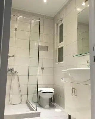 a bathroom with a shower and a toilet and a sink at Spacious & Sunny Kolonaki Apt 5 mins metro/ACx3/1.5 BT in Athens