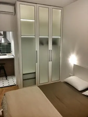 a bedroom with glass closet doors and a bed at Central new Kolonaki apartment in Athens