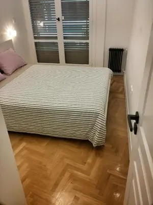 a bed in a room with a wooden floor at Central new Kolonaki apartment in Athens