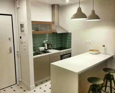 a kitchen with a sink and a counter with stools at Central new Kolonaki apartment in Athens