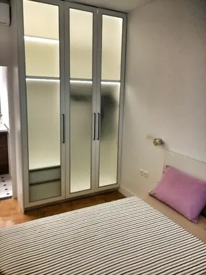 a bedroom with a glass closet with a purple pillow at Central new Kolonaki apartment in Athens