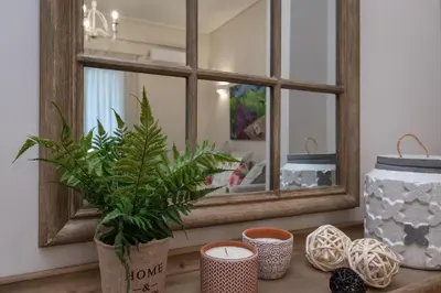 a mirror on a table with vases and a plant at Absolute Athens III in Athens