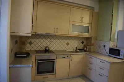 a kitchen with wooden cabinets and a sink and a microwave at Historic Center Apartment at Thisseio in Athens