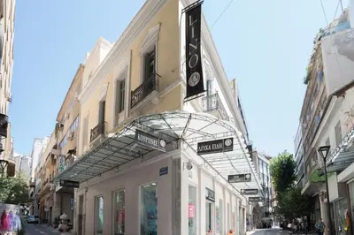 a building with a sign for a store on a street at Delfini Home Plaka/Acropolis in Athens