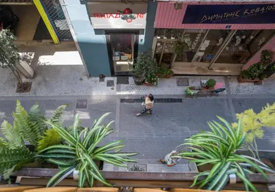 a person riding a skateboard down a street with plants at Delfini Home Plaka/Acropolis in Athens