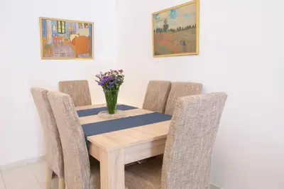 a dining room table with chairs and a vase of flowers at Zeas Apartment in Piraeus