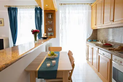 a kitchen with a wooden table with a bowl of fruit on it at Zeas Apartment in Piraeus