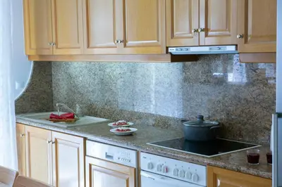 a kitchen with wooden cabinets and a stove top oven at Zeas Apartment in Piraeus