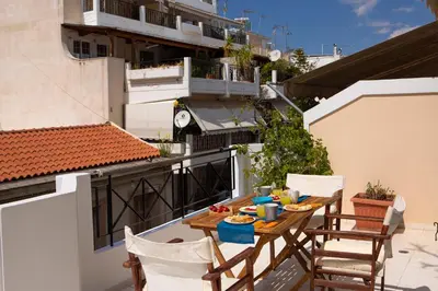a table and chairs on the balcony of a building at Zeas Apartment in Piraeus
