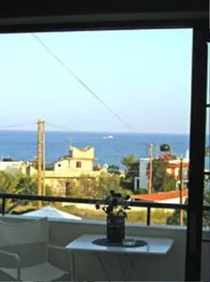 a room with a view of the ocean from a window at Anna Studios in Agia Marina Aegina