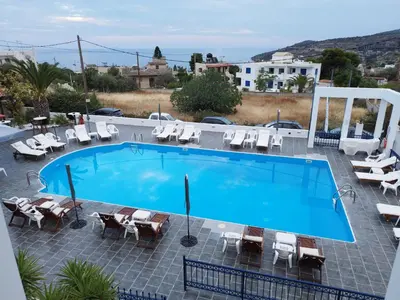 a swimming pool with chaise lounge chairs at Anna Studios in Agia Marina Aegina