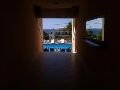 a hallway to a house with a view of a pool at Anna Studios in Agia Marina Aegina
