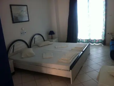 a large bed in a room with a window at Anna Studios in Agia Marina Aegina
