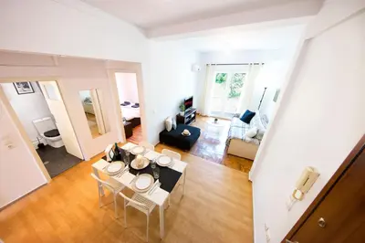 a living room with a table and chairs in it at Unique views of Filopapou hill in Acropolis Area! in Athens