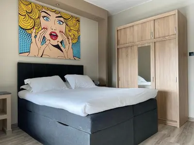 a bedroom with a bed with a painting on the wall at Connect Studios & Apartments in Athens