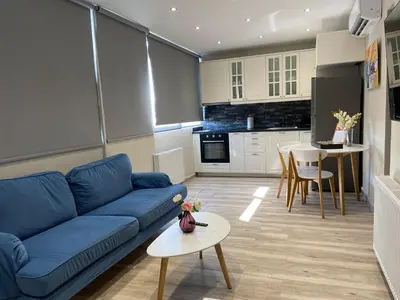 a living room with a blue couch and a kitchen at Connect Studios & Apartments in Athens