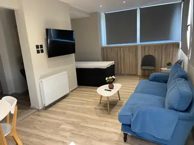 a living room with a blue couch and a bed at Connect Studios & Apartments in Athens