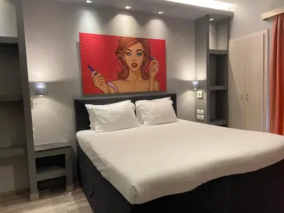 a bedroom with a bed with a painting on the wall at Connect Studios & Apartments in Athens