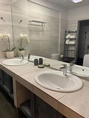 a bathroom with two sinks and a large mirror at Connect Studios & Apartments in Athens