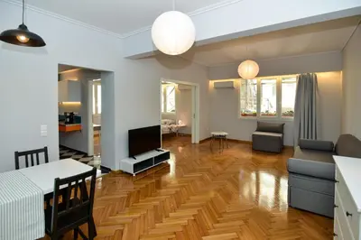 a living room with a couch and a table and a television at Athens' heart Syntagma metro apartment in Athens