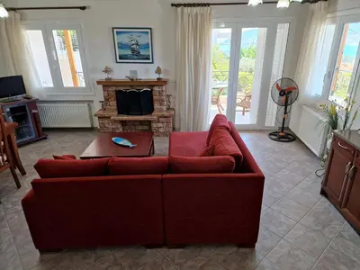 a living room with a red couch and a fireplace at The Mirador Boutique Villa with Scenic Sea View in Porto Rafti