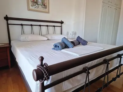 a bed with two blue pillows on it at The Mirador Boutique Villa with Scenic Sea View in Porto Rafti