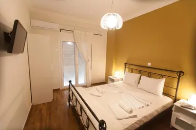 a bedroom with a bed with white sheets and a window at Athens City Themis 3 in Athens