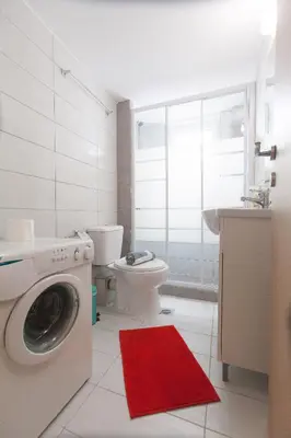 a bathroom with a washing machine and a toilet at Athens City Themis 3 in Athens