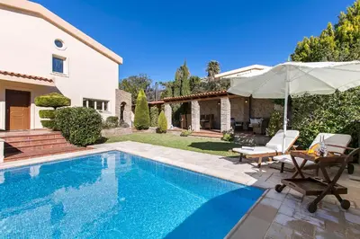 a villa with a swimming pool and a house at Villa Melia Athenian Riviera in Sounio