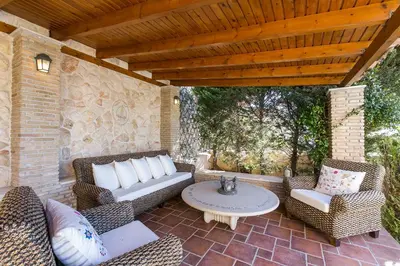 an outdoor patio with wicker chairs and a table at Villa Melia Athenian Riviera in Sounio